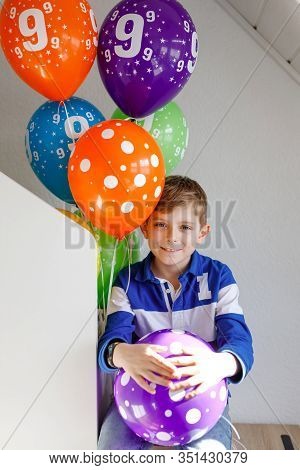 Portrait Of Happy Kid Boy With Bunch On Colorful Air Balloons On His Birthday. Smiling School Child 