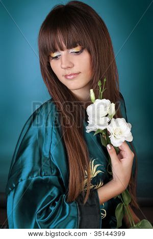 Vacker kvinna med rak lång hår och blommor i handen
