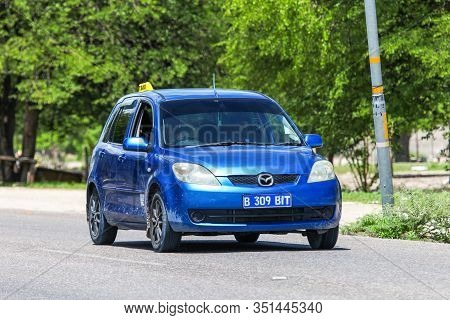 Maun, Botswana - February 9, 2020: Blue Taxi Car Mazda Demio In The Town Street.