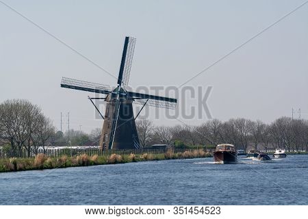 Waterways And Canals In North Holland With Boats And View On Traditional Dutch Mill, Spring Landscap