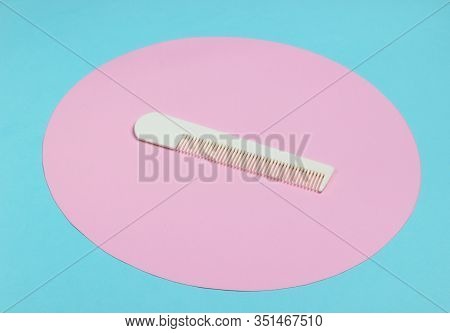 White Hair Combon On Blue Pastel Background With Pink Pastel Circle. Creative Minimalistic Beauty An