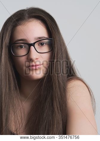 Portrait Of A Serious Bespectacled Long-haired Brunette Teen Girl
