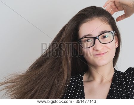 Portrait Of A Smiling Bespectacled Long-haired Brunette Teen Girl
