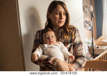 Young Mother Gently Holding Her Baby Near The Window At Home. Family, Childhood And Maternity Concep