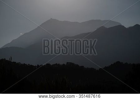 Нigh Mountain Silhouettes In Haze With Stepped Lighting In Backlight In The Evening