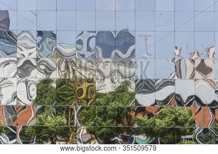 Detail Of Reflective Glazed Building In Which The Surrounding Constructions Are Reflected, Deformed.