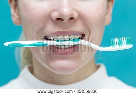 Beautiful Girl Clamps A Toothbrush Between Teeth , Close-up