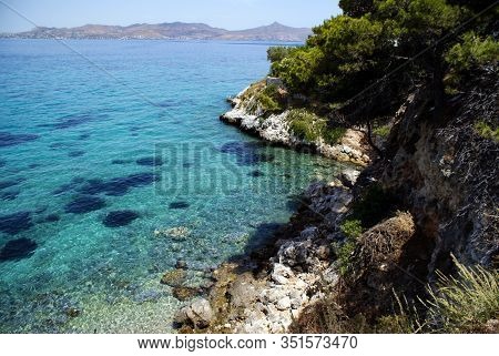 Greece, The Island Of Angistri, Near Athens.  Crystal Clear Water. Rocky Pine Covered Cliffs.  In Th