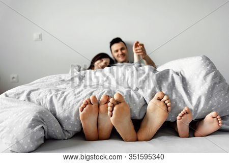 A Young Family, A Family Wakes Up In The Morning,feet On The Bed,healthy Legs Of A Young Family,fami