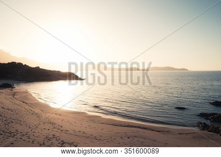 Sun Setting Over The Golden Plage De Sainte Restitude Beach In The Balagne Region Of Corsica With Th