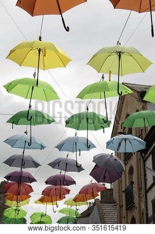 Wales, The Historic Town City Of Caernarfon.  Inside The Walled Town, Jolly, Coloured Umbrellas Are 