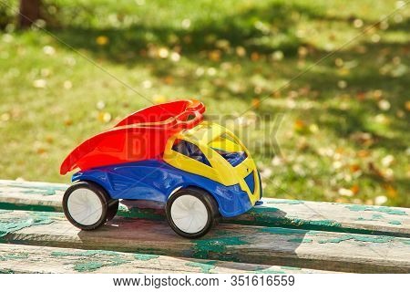 Colorful Toy Truck On Grass Background. Babycar Outdoors.