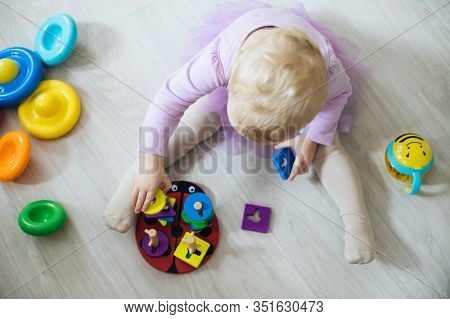 Girl Plays Toys In Living Room. Montessori Wooden Toy Folded Pyramid. Circle, Quadra, Triangle, Rect