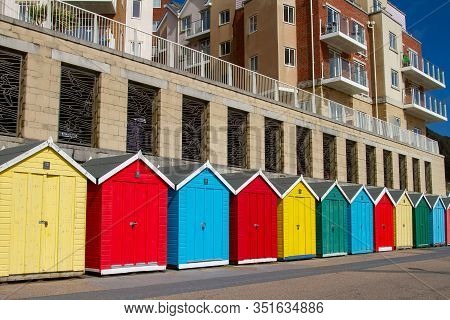 Boscombe, Dorset, England-march 27,2016: A Row Of Colorful Beach Huts Nestle Below The Honeycombe Ch