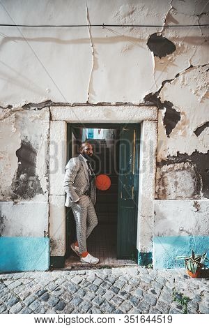 A Stylish Fancy African Man With A Beard Is Standing In The Doorway With A Basketball In Hands; Blac