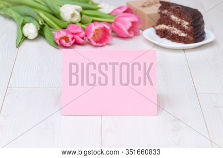 Paper Card, Bouquet Of Pink Tulips, Chocolate Cake. Pressent Box On White Wooden Background. Copy Sp