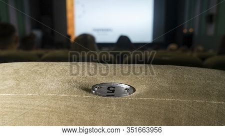 Watching Films. Blurred Movie On The Big Screen In The Cinema And Chair With Nomber..