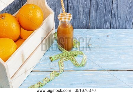 Lots Of Oranges And A Bottle Of Juice, Measuring Tape On A Wooden Textured Background. Fitness, Spor