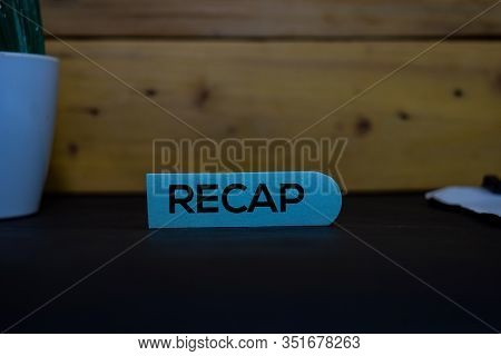 Recap Write On A Sticky Note Isolated On Wooden Background.