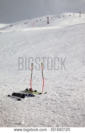 Skiing Equipment: Ski Poles, Skis On Snowy Slope, Chair Lift And Gray Cloudy Sky At Background. Ski 