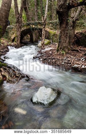 Beautiful Medieval Stoned Bridge Or Milia With River Full With Water Flowing At Troodos Mountains In
