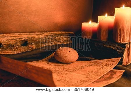 Old Plans Next To Other Elements In The Light Of Candles In Rustic Wood