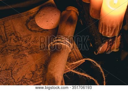 Old Plans Next To Other Elements In The Light Of Candles In Rustic Wood
