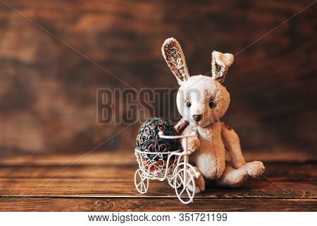 Vintage Egg In Easter Bice, Rabbit Sitting Near Bicycle. Holiday Composition On Wooden Background.