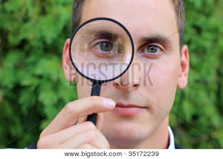 Homme regardant à travers la loupe alors que c'est grave
