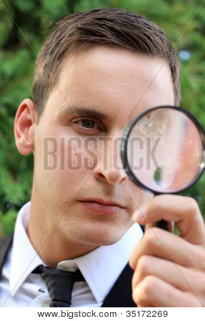 Homme regardant à travers la loupe