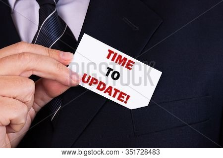 Businessman Putting A Card With Text Time To Update In The Pocket