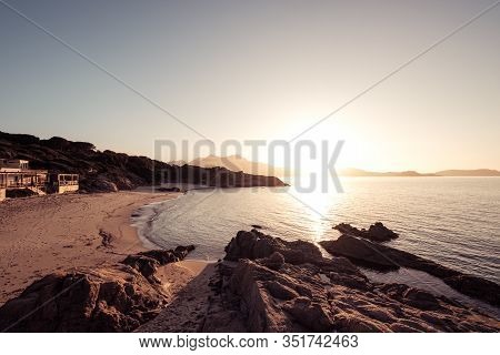Sun Setting Over The Golden Sand Of Plage De Sainte Restitude Beach In The Balagne Region Of Corsica