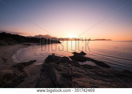 Sun Setting Over The Golden Sand Of Plage De Sainte Restitude Beach In The Balagne Region Of Corsica