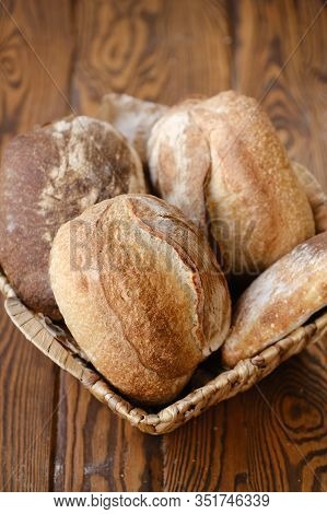 Different Buns Of Fresh Bread On A Brown Vintage Background. Freshly Baked Wheat Bread, Still Life W