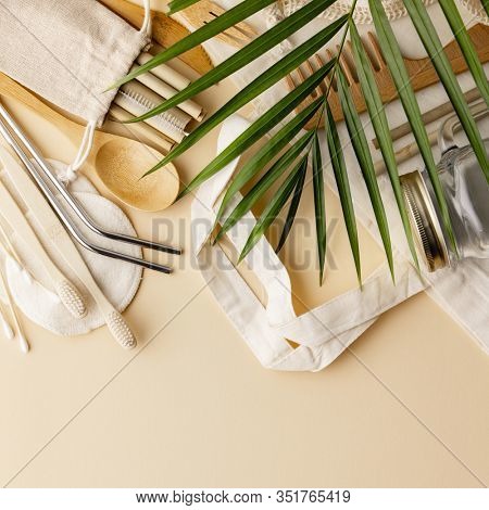 Cotton bag, bamboo cultery, glass jar, bamboo toothbrushes, hairbrush and straws on color background, flat lay.