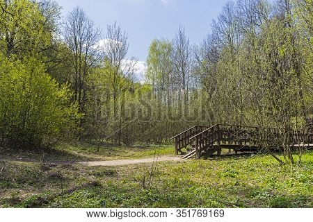 A Wooden Pedestrian Bridge Over A Stream At The Bottom Of A Ravine. Bitsa Park, Moscow, Russia. Sunn