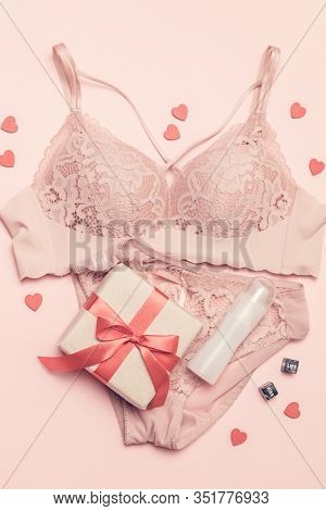 Top View Of Lace Pink Underwear Surprise Gift, Black Cubes And Lubricant On A Pink Background