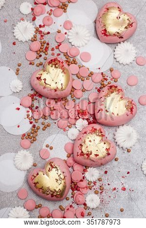 Pink Hearts From Tempered Chocolate With Chocolate Drops, Meringues And Dried Berries On Grey Backgr