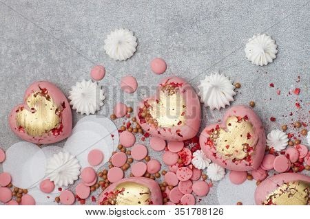 Pink Hearts From Tempered Chocolate With Chocolate Drops, Meringues And Dried Berries On Grey Backgr