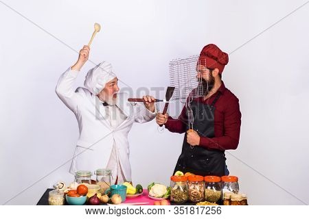 Cook. Chef. Two Chefs Fighting On Kitchen. Professional Culinary. Bearded Man In Kitchen Apron. Bear