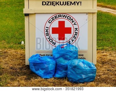 Skarlin, Poland - July 18, 2019: Container Of The Polish Red Cross For Used Donated Clothing, Shoes 