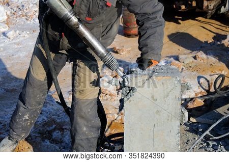Demolition Of Rebots At The Construction Site. Builder With Hammer Breaking Pills. Demolition With A