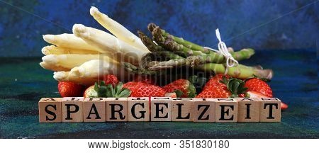 White And Green Asparagus With Strawberries On Rustic Background With Spargelzeit Wooden Letter.