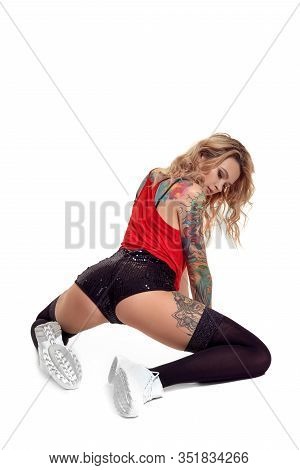 Sexy Blond Twerk Woman With Tattoed Body And Long Curly Hair Is Posing In Studio.