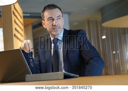 Executive man working in hotel lounge with laptop