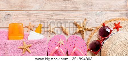 Flip Flops, Straw Hat, Starfish, Sunscreen Bottle, Body Lotion Spray On Wooden Background Top View B