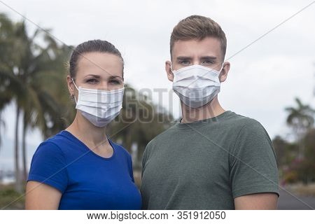 Beautiful Serius Couple, Guy, Girl In Protective Sterile Medical Mask On Face Looking At Camera Outd