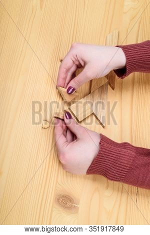 Girl Collects A Wooden Tangram Puzzle On A Wooden Table.