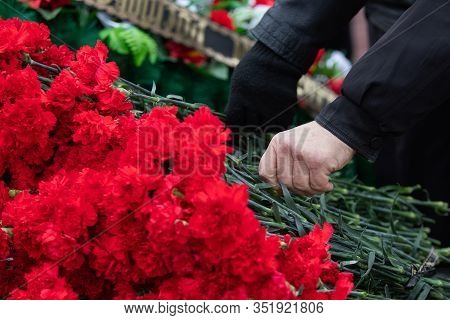 Red Carnations Are Laid On The Marble Memorial In Honor Of Those Killed In The War