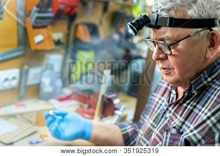 Senior Craftsman Portrait With Headlamp Led Torch Working In Workhop With Tools And Equipment On Bac